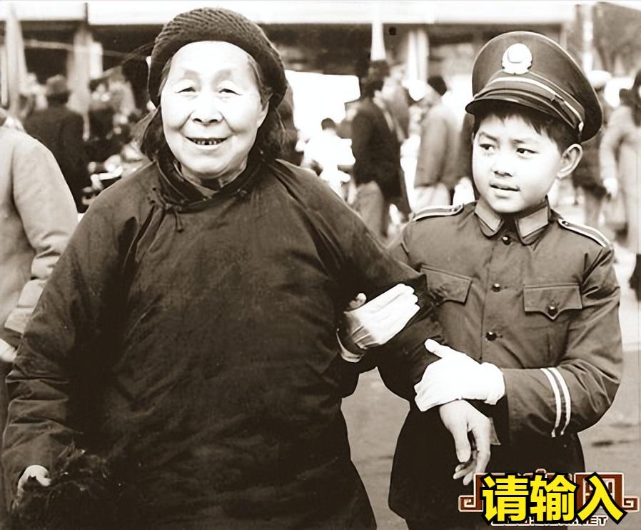 看这张照片，这是多年前，西安市二府街小学“少年交警分队”队员在西华门十字搀扶老奶