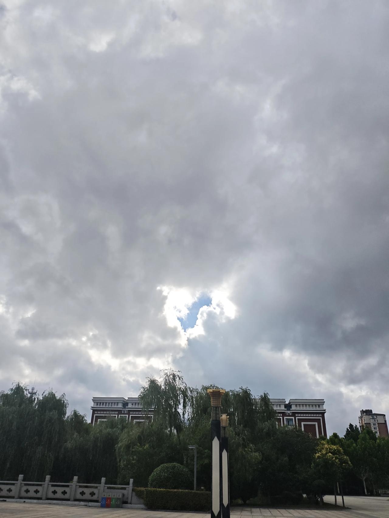 今早乌云要把我们学校包围了，阳光只能从缝隙中透出来，有些压抑感！