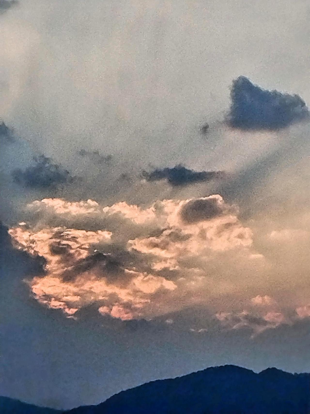 夕阳西下，云海翻滚，静谧而壮丽。远处的山峦在夕阳余晖的映照下，仿佛被镀上了一层金