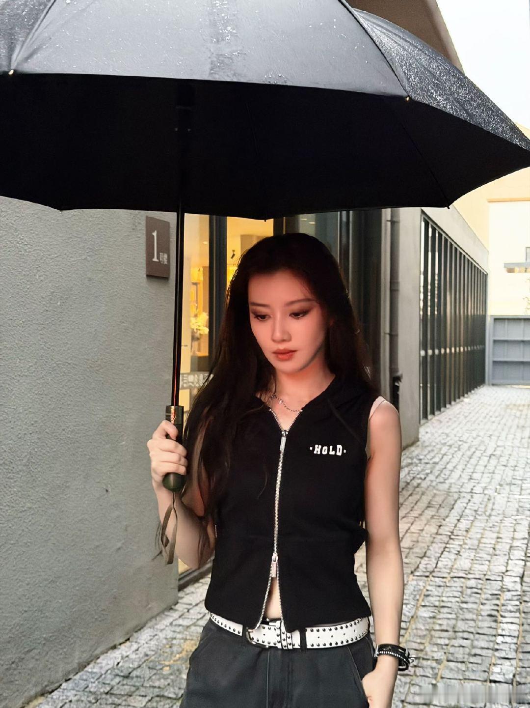 王鹤润雨中撑伞酷姐感 最新雨中撑伞写真好A～一身黑色工装套装配黑长直发型，利落飒