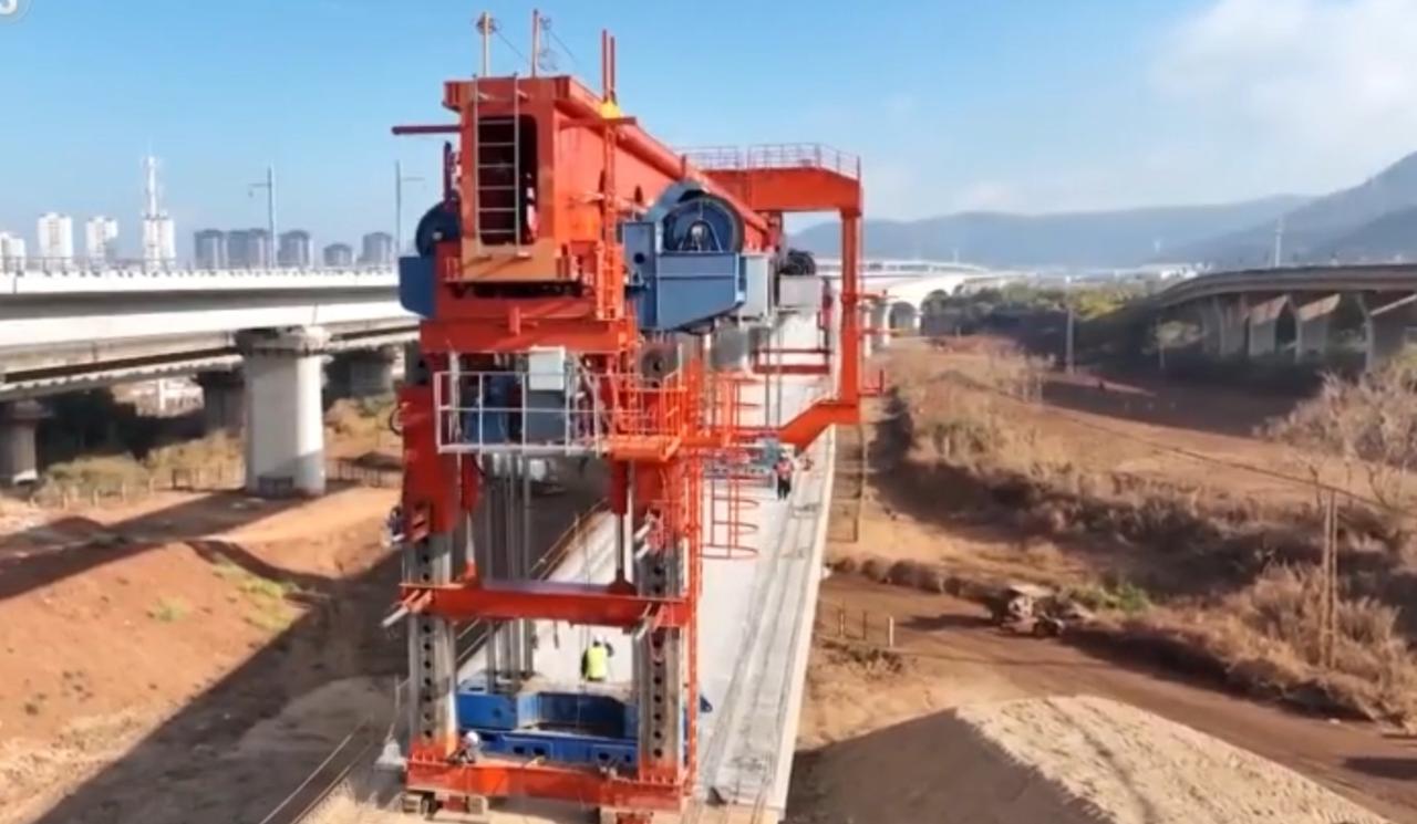 渝昆高铁桥梁建设已全面完成，红色架桥机在绵延的高架上精准作业，一条条银灰色的桥梁