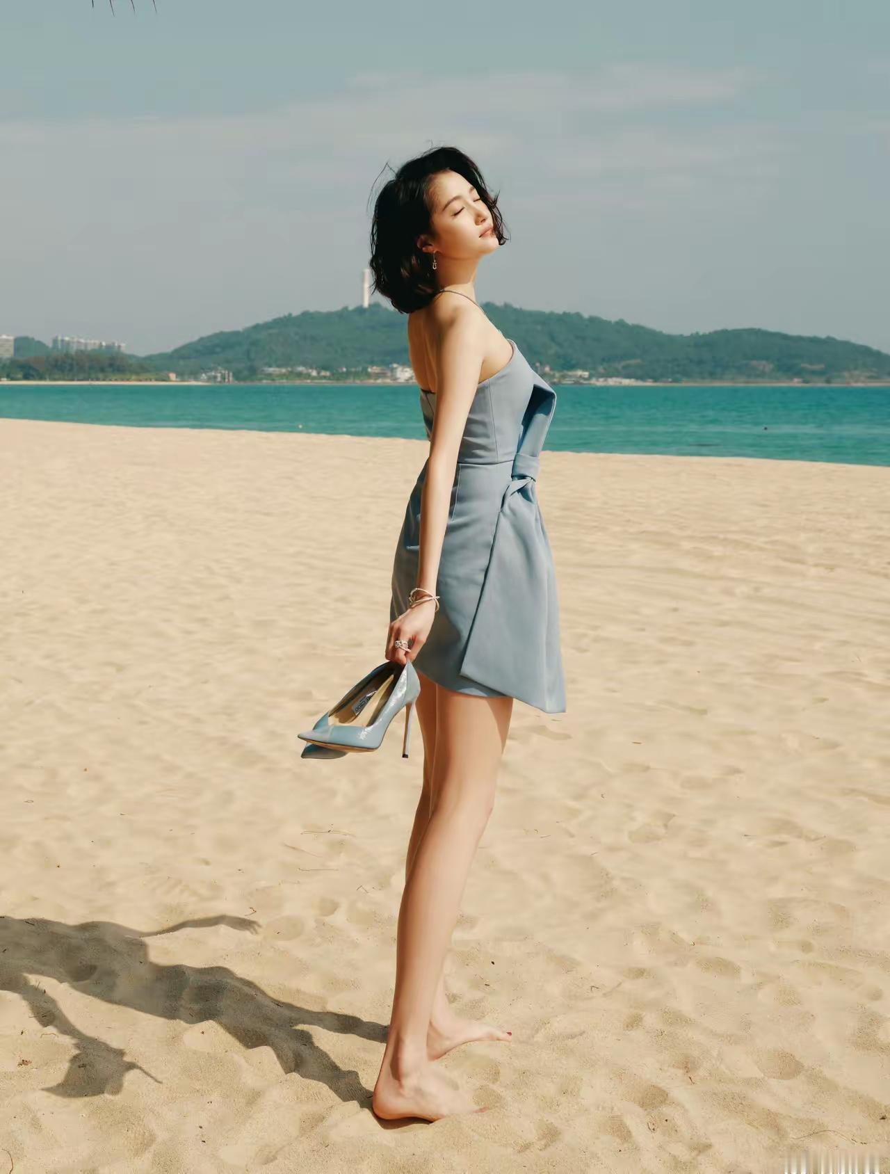 沙滩上的优雅时光，轻纱裙摆随风飘扬。
关晓彤美腿玉足海边漫步照 海边白裙随拍 海