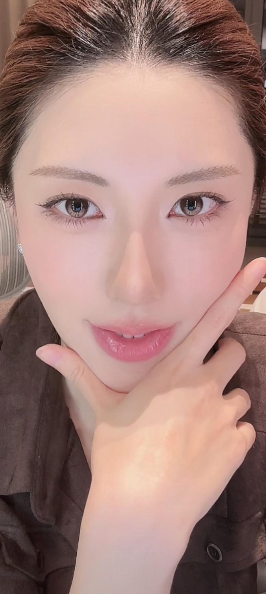 这位美女在微笑，手托着脸。