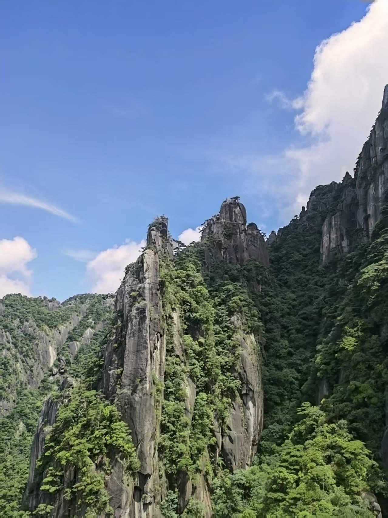 晒图笔记大赛峻峭石峰拔地而起，岩壁苍劲，青松嵌于山石之间。澄澈蓝天浮着朵朵白云，