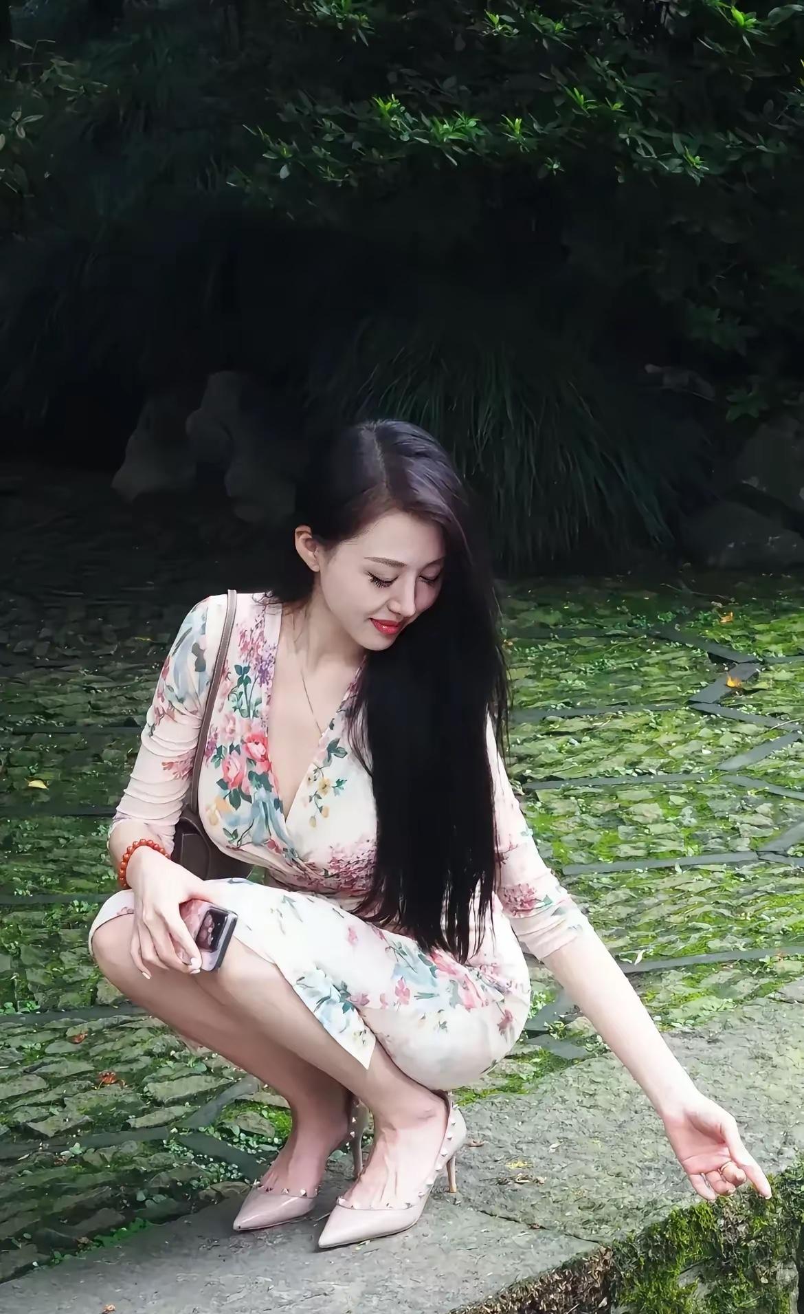 在绿意盎然的公园里，她优雅地蹲下，仿佛在寻找自然的秘密。