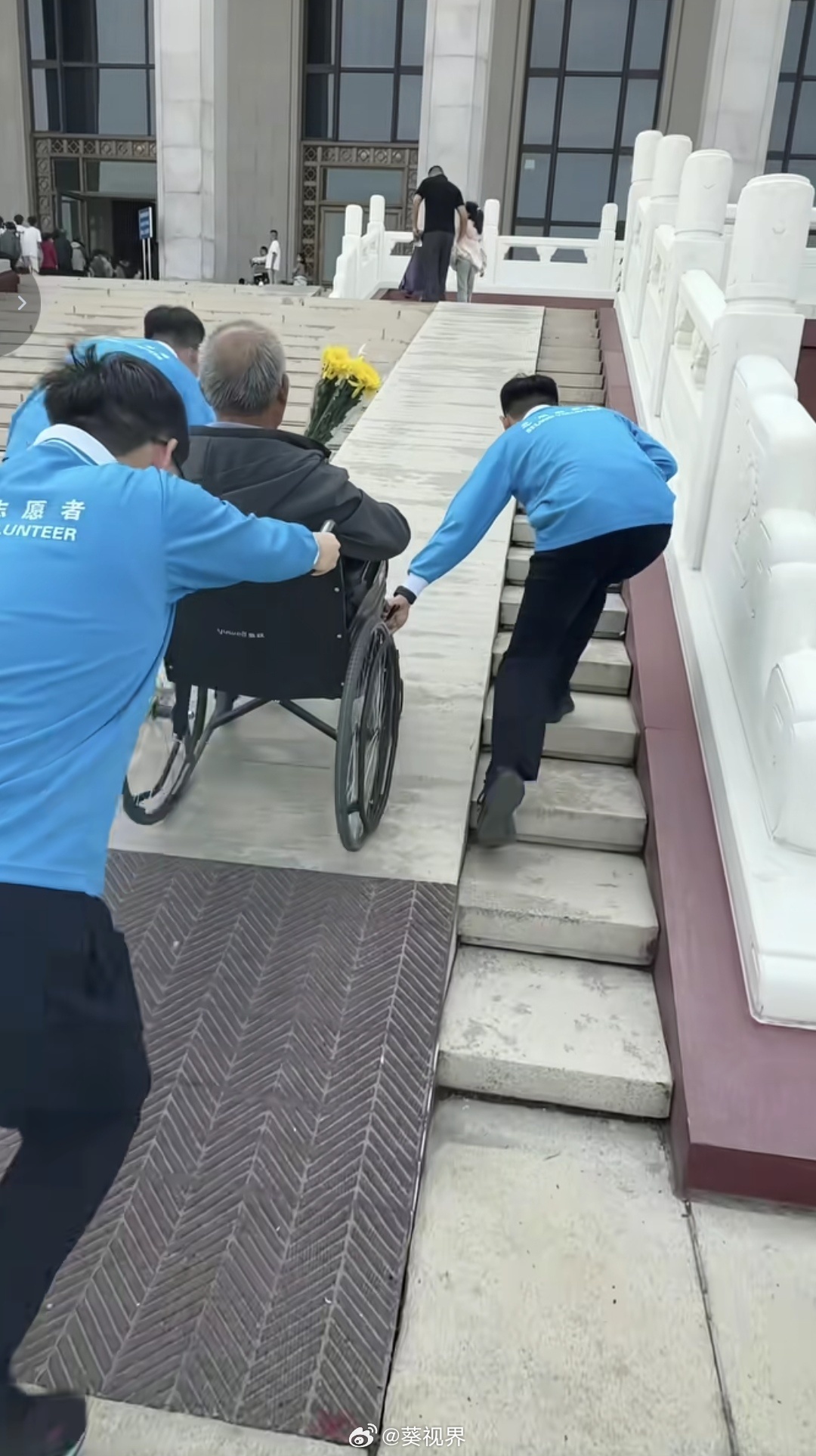 毛主席纪念堂前，轮椅上的老人，怀抱鲜花。这样的老人很多，他们都是毛主席亿万儿女中