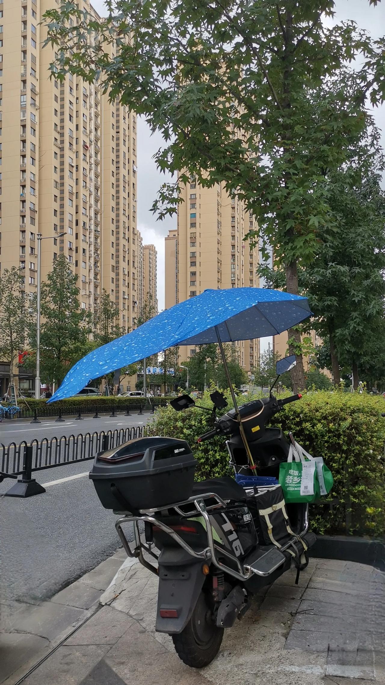 电动自行车上支一把伞，像一只风筝一样。平时人们打一把伞，有时风稍微大一点，就会把
