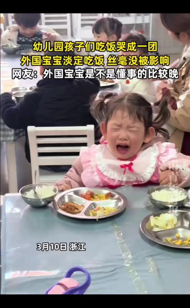幼儿园孩子们吃饭哭成一团，外国宝宝淡定吃饭丝毫没被影响。
3月10日浙江时报。