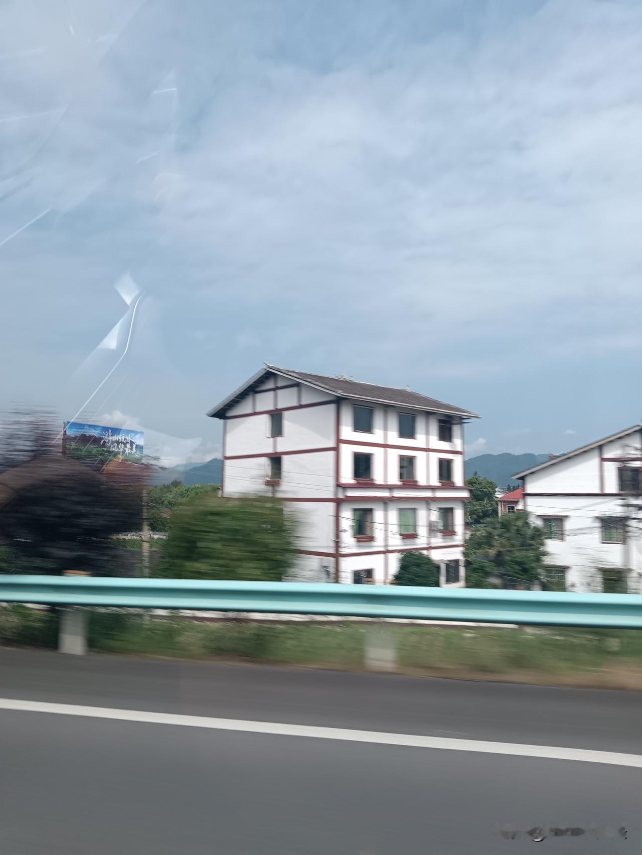 车窗外的风带着山野的气息，掠过高速旁的护栏，也掠过这排白墙红边的黔北民居。

蓝