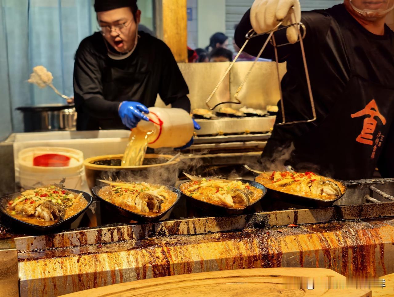 铁板烤鱼摊位前人气很旺，锅里滋滋作响，热气腾腾，看着格外诱人。

一份48元，价
