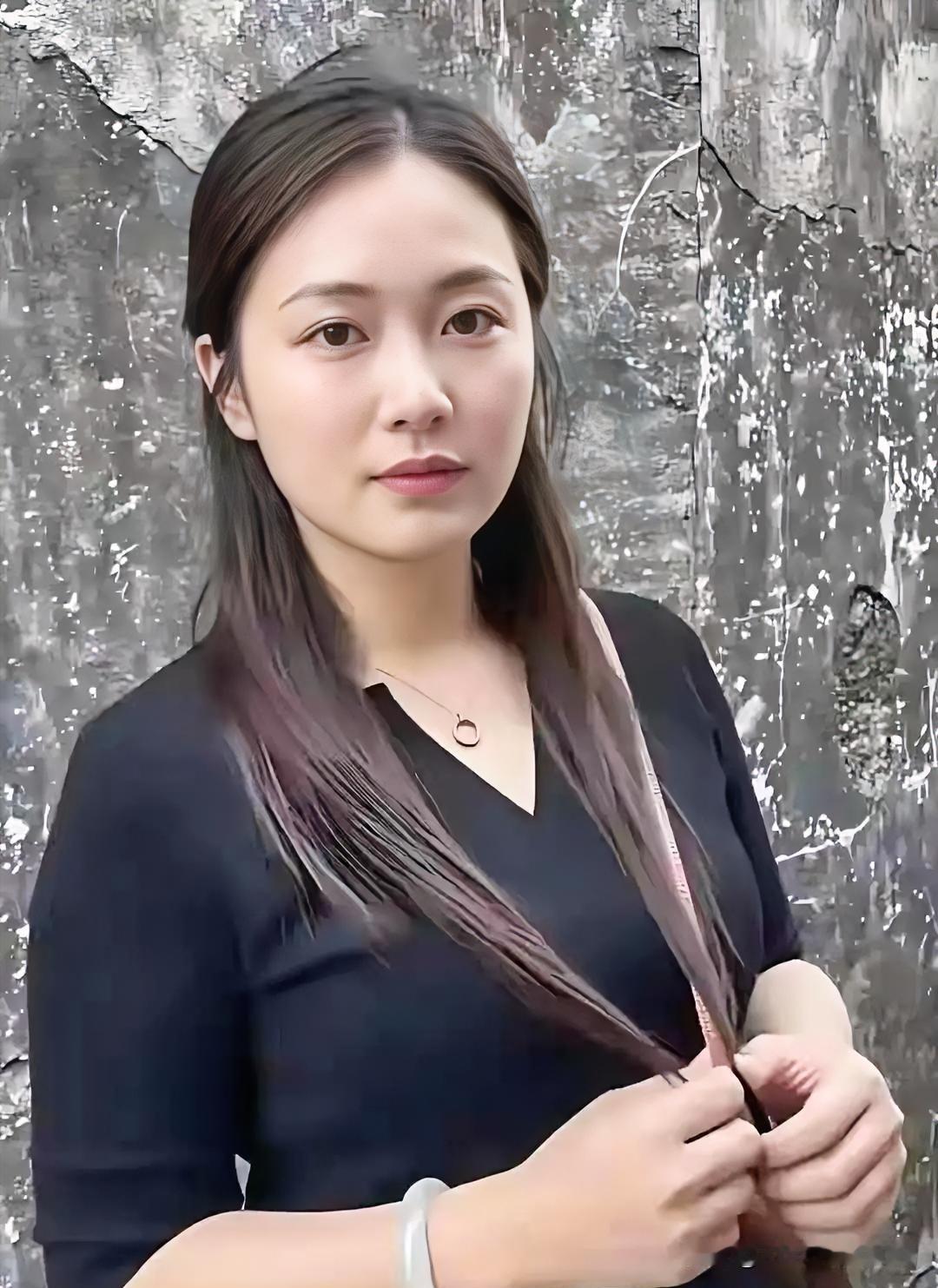素衣如墨，玉镯生光。斑驳墙前，青丝轻绕，清丽面容与简约穿搭交织，尽显静谧文艺之美