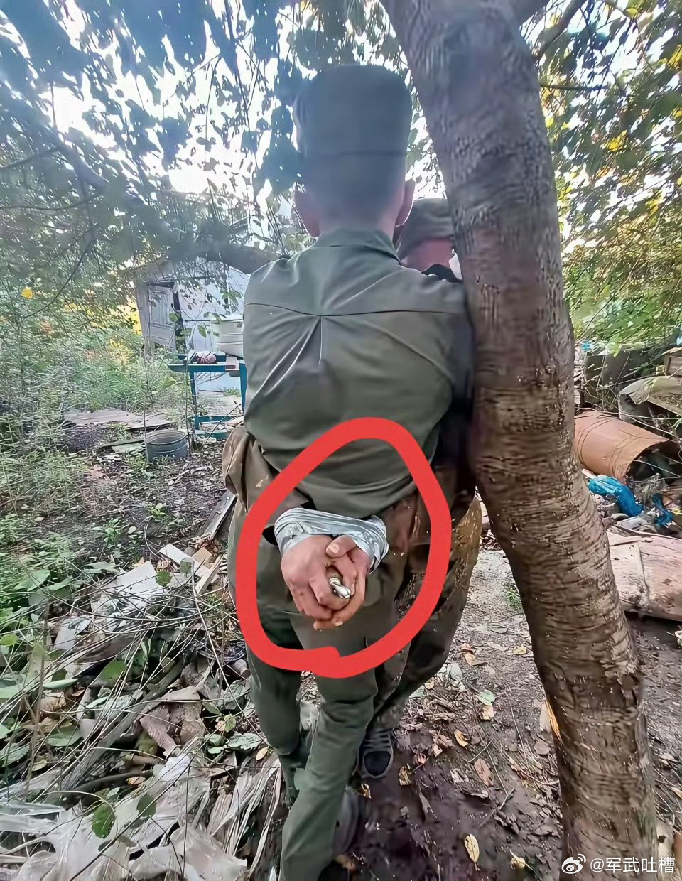 看这军装有可能是两个佤邦军被俘虏了两个人绑在一起另一个人手上还握着手雷这手雷很可