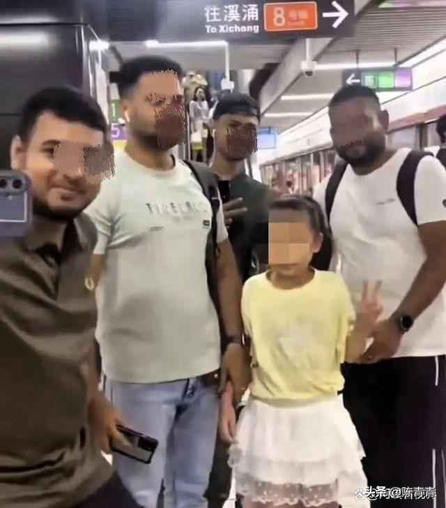 小女孩和四个外国人在一起照相。她虽比出剪刀手姿势，可脸上的笑容有点僵硬。

时间