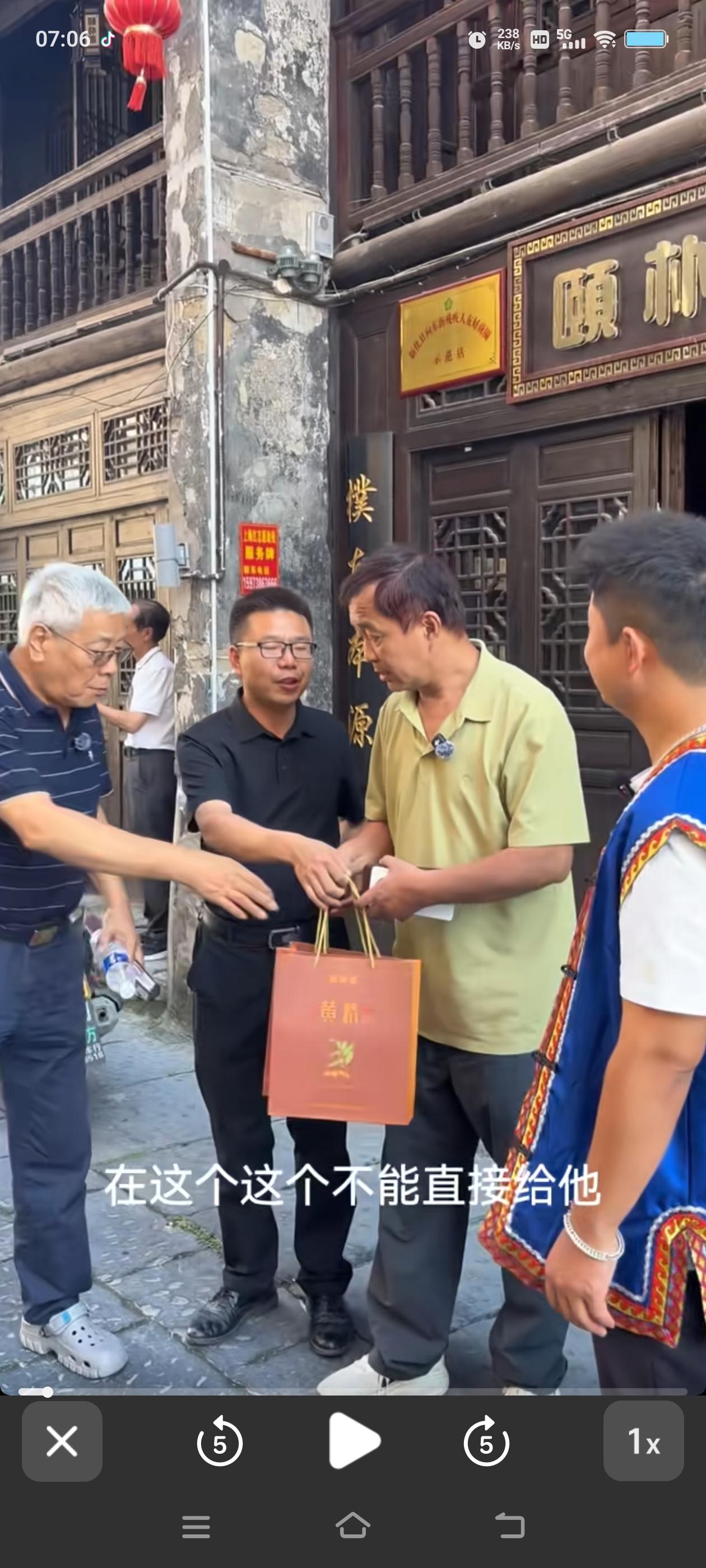 沈巍顺手接过了那份随手礼，张金卫连忙上前拦住，一把夺过来说，这东西不能直接递给他