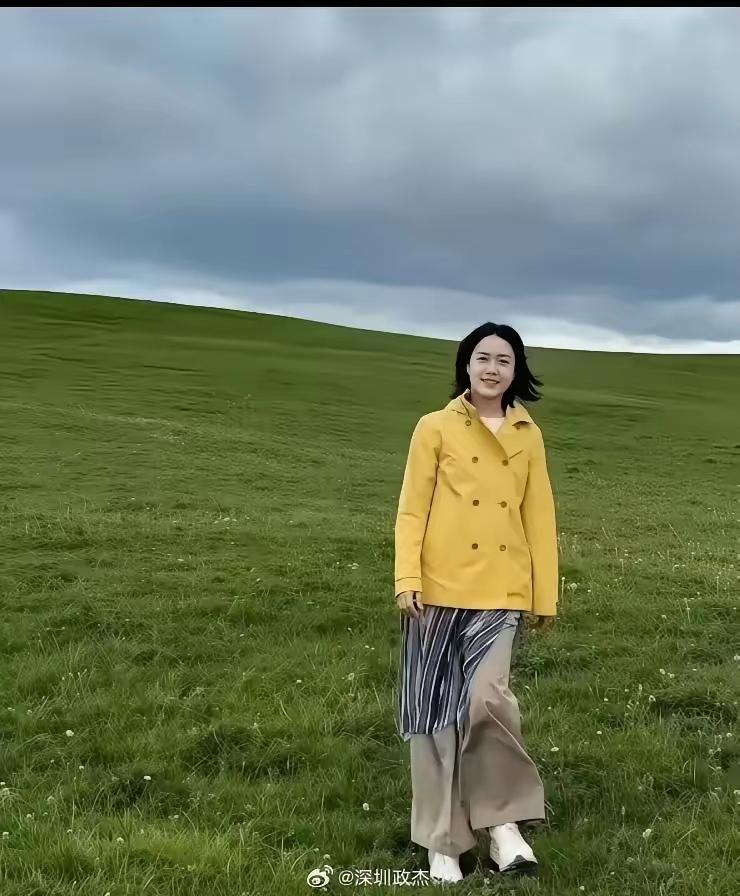 好明媚的翁帆 ！穿着明黄色风衣 ，卡其色裤子的翁帆站在草原上，整个人看起来好年轻