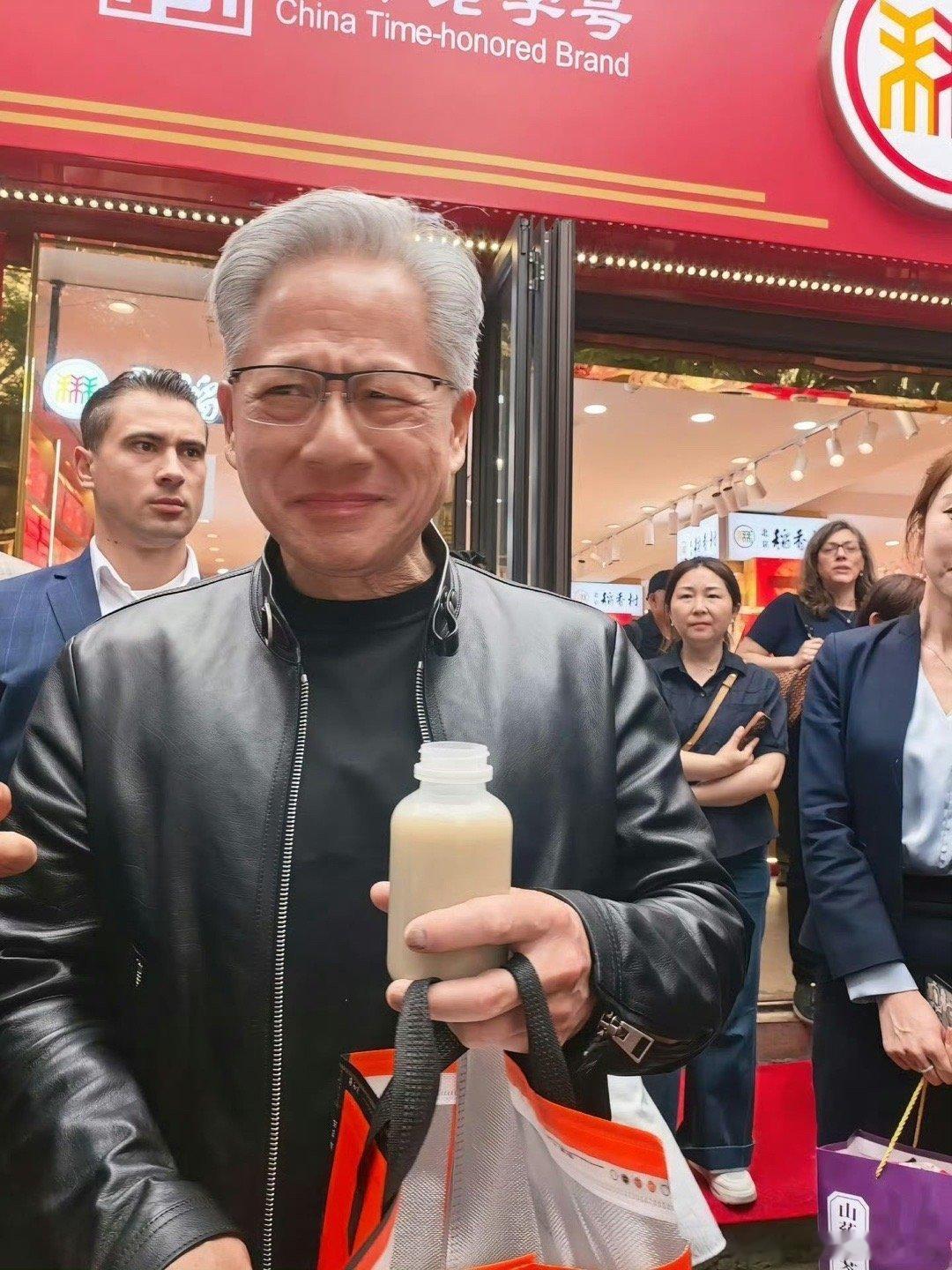 黄仁勋被投喂北京豆汁眉头紧锁 黄仁勋刚在南锣鼓巷接过路人一瓶灰色饮料喝完之后面露