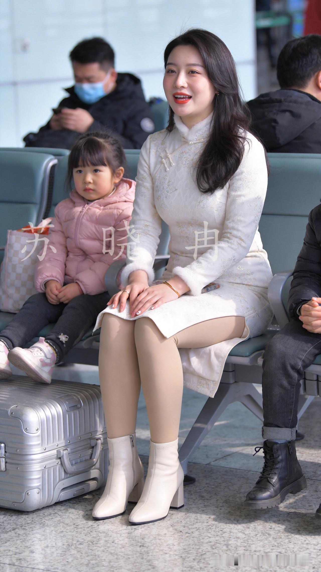 春运返程的候机厅里，人潮涌动，行李箱的轮子在地面上划出细碎的声响。
她穿着一身素