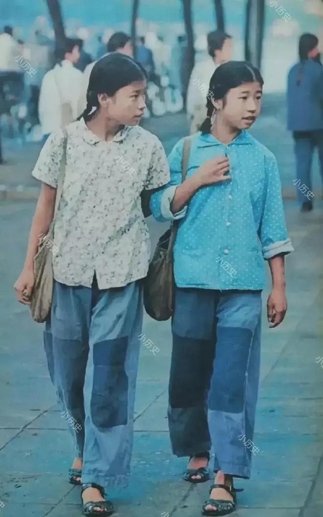 1972年，北京街头，两个穿着补丁衣服的学生，她们穿着碎花衬衫，脚上穿着凉鞋，裤