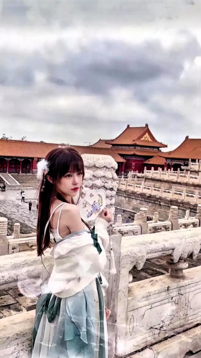 想象一下，穿越千年的古风少女漫步在故宫青石板路上，那画面简直美炸。就像唐艺昕粉发