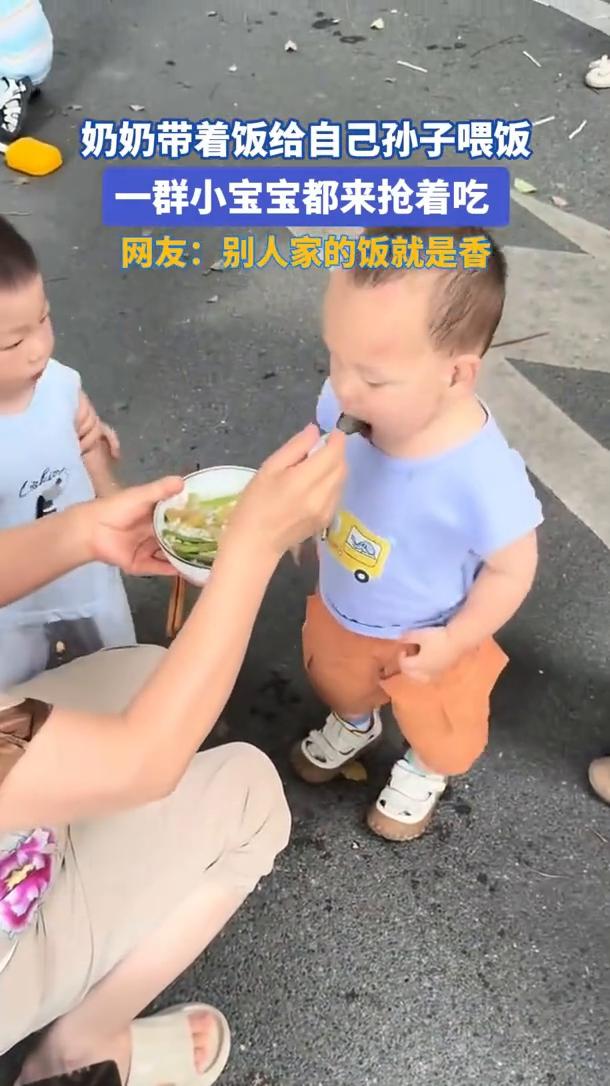 奶奶带着饭给自己孙子喂饭，一群小宝宝都来抢着吃。网友：别人家的饭就是香。
奶奶带