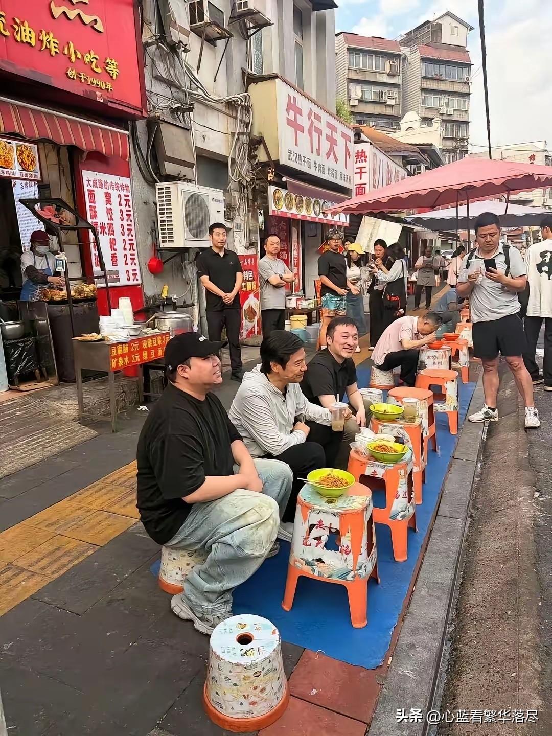 估计也只有在武汉，才能看到这种坐在路边板凳上吃早餐的场景吧？真的很好奇，这到底是