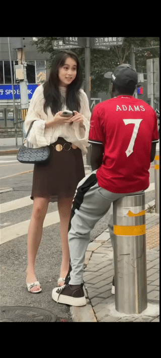 网友在街头拍到一名年轻女子主动搭讪一名黑人男子？
两个人看起来聊天聊的很开心。