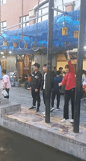 农村小姐姐玩吊环，手拿把掐。开始她觉得很好奇，水面上放些吊环，居然有男生玩着玩着