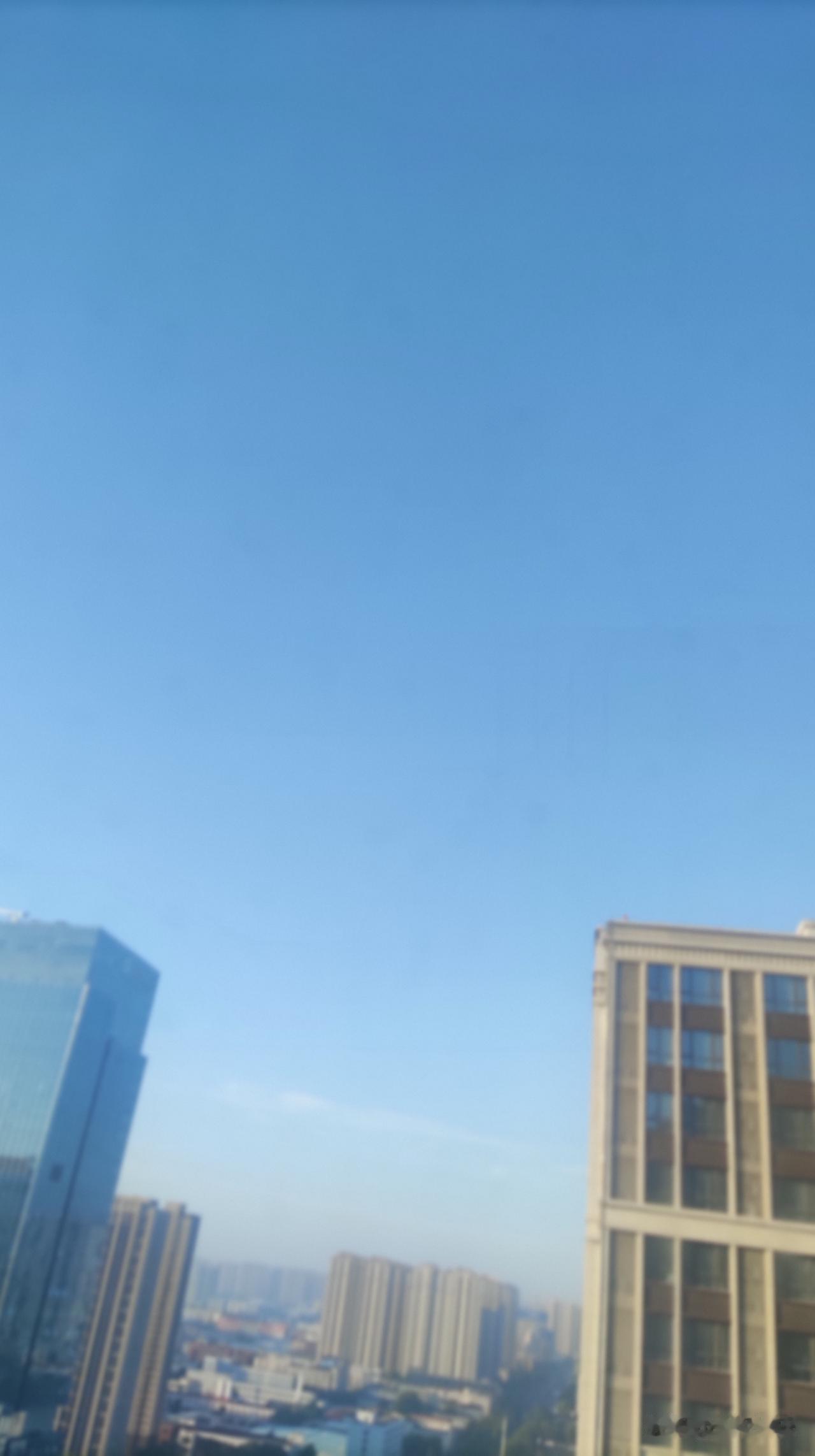 清晨推开窗，俯瞰整片城市楼宇，澄澈干净的晴空铺满视野，淡淡的薄雾轻轻笼罩远处成片