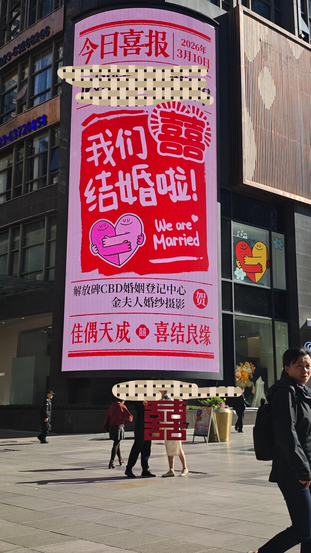 闺蜜的女儿今天结婚啦！她把女儿结婚的巨幅广告发给我，两位新人站在广告面前相拥而吻