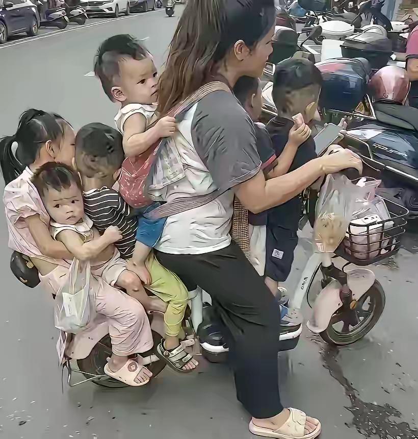 一个妈妈六个娃！

 广东街头一个骑电动车的妈妈，带着六个娃娃，远远看上去， 以