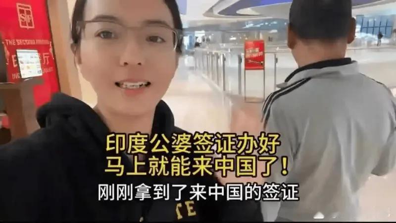 这是一张短视频截图，画面主体是一位正在自拍的女士，背景是机场或商场大厅的环境，右
