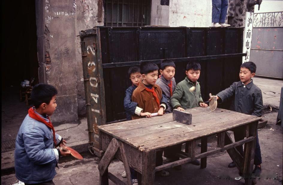 1980年的上海工人聚居区内，沪南电表厂的一隅，一群职工子弟正围在一张由废旧桌子