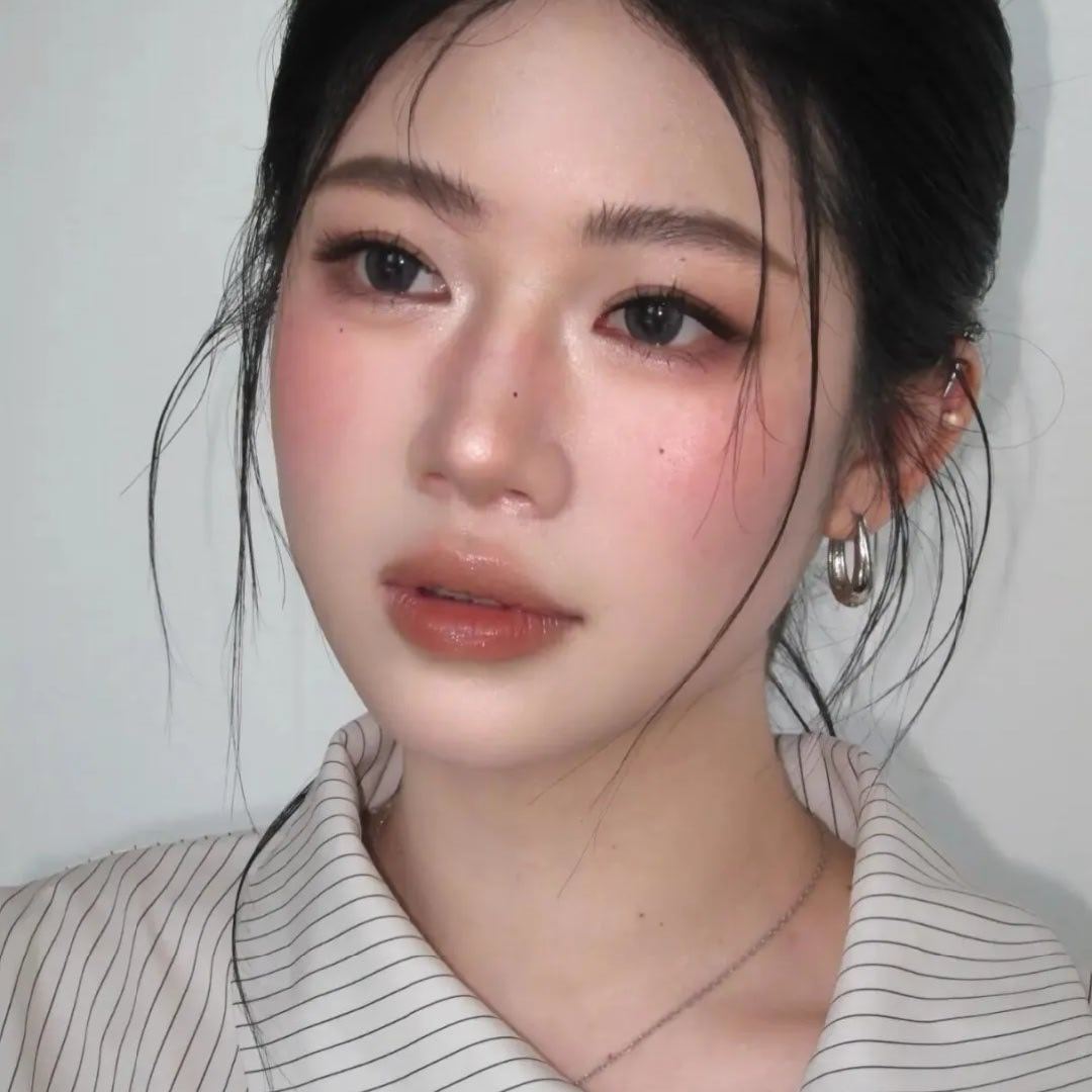 清冷氛围感杏粉淡妆，知性通勤妆造，利落盘发留出几缕碎发柔化线条，棕调温柔眼妆自然