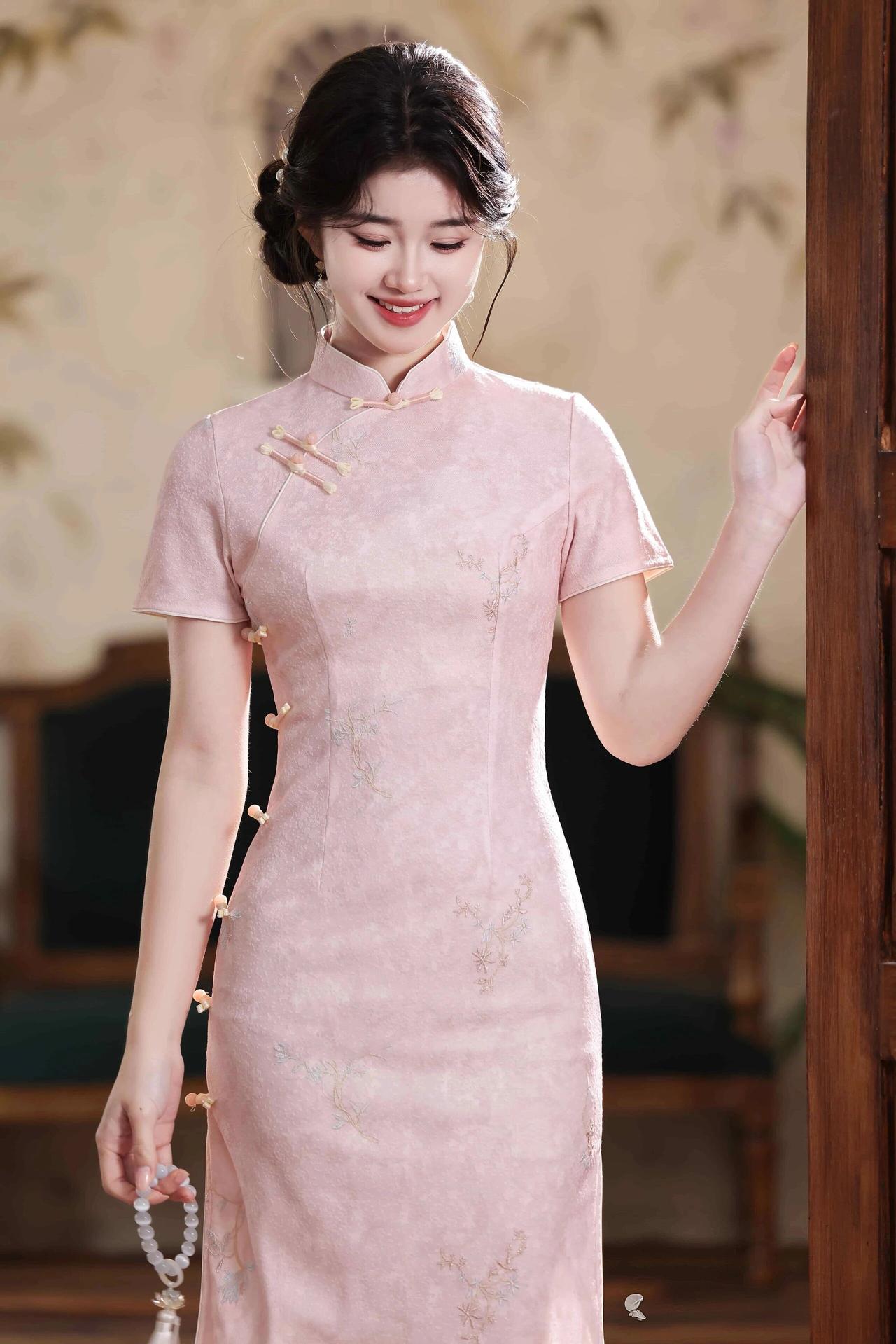 旗袍剪裁修身，勾勒出曼妙身姿，淡雅的暗纹与精致的盘扣相得益彰，简约又不失韵味。乌