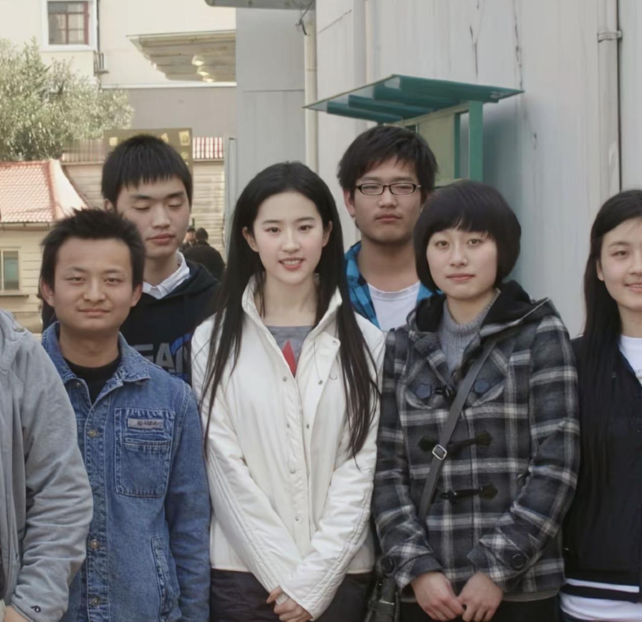 2009年，《恋爱通告》刘亦菲和剧组工作人员的合影。那时的刘亦菲20出头，一身简