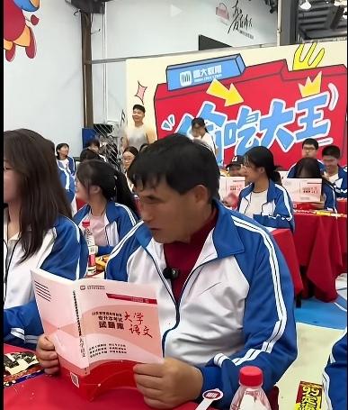 先不说大衣哥，这主办方要说明什么？校长要干什么？
     这是在教室里，后面的
