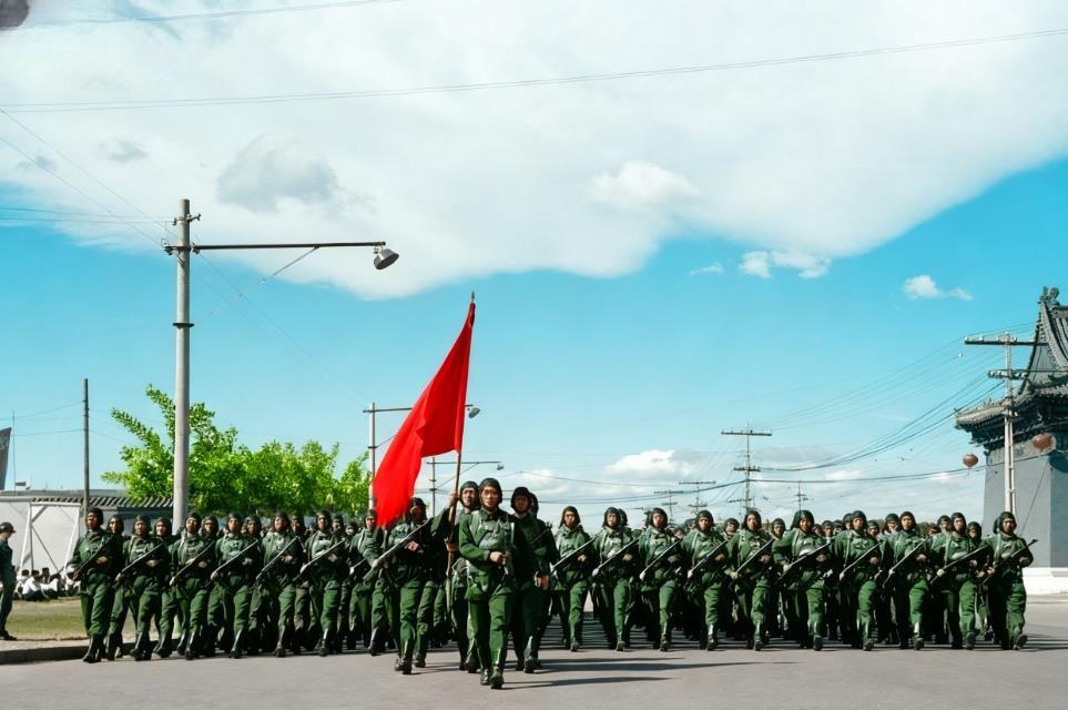 这张照片定格了1951年国庆阅兵式上，解放军伞兵部队行进在天安门广场附近的场景。