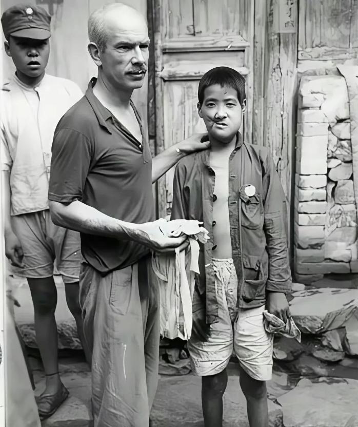 1939年，白求恩给面部中弹的小八路拆线。 随军的摄影师沙飞，拍下了白求恩拆线的