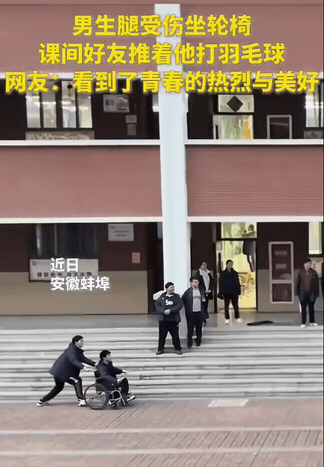 太暖了！安徽蚌埠，一个男生腿受伤，只能坐轮椅上课。课间看到大家打羽毛球，他坐在旁