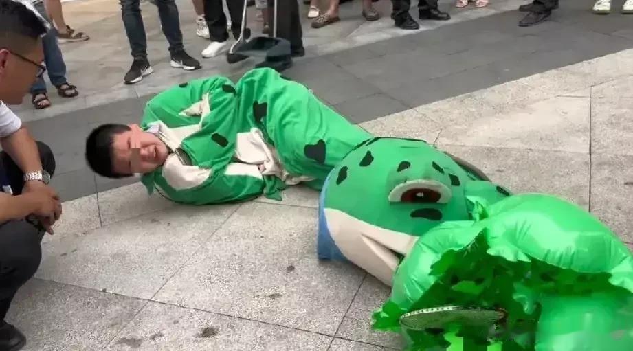 四川遂宁的万达广场，一名10几岁的男孩穿着青蛙服卖玩具，结果保安几次劝导都没有用