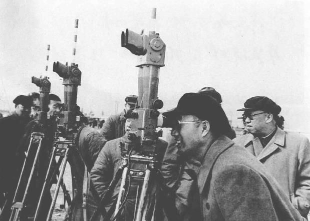 罗荣桓(右1)、徐向前(看经纬仪者)元帅观看炮兵侦察器材。