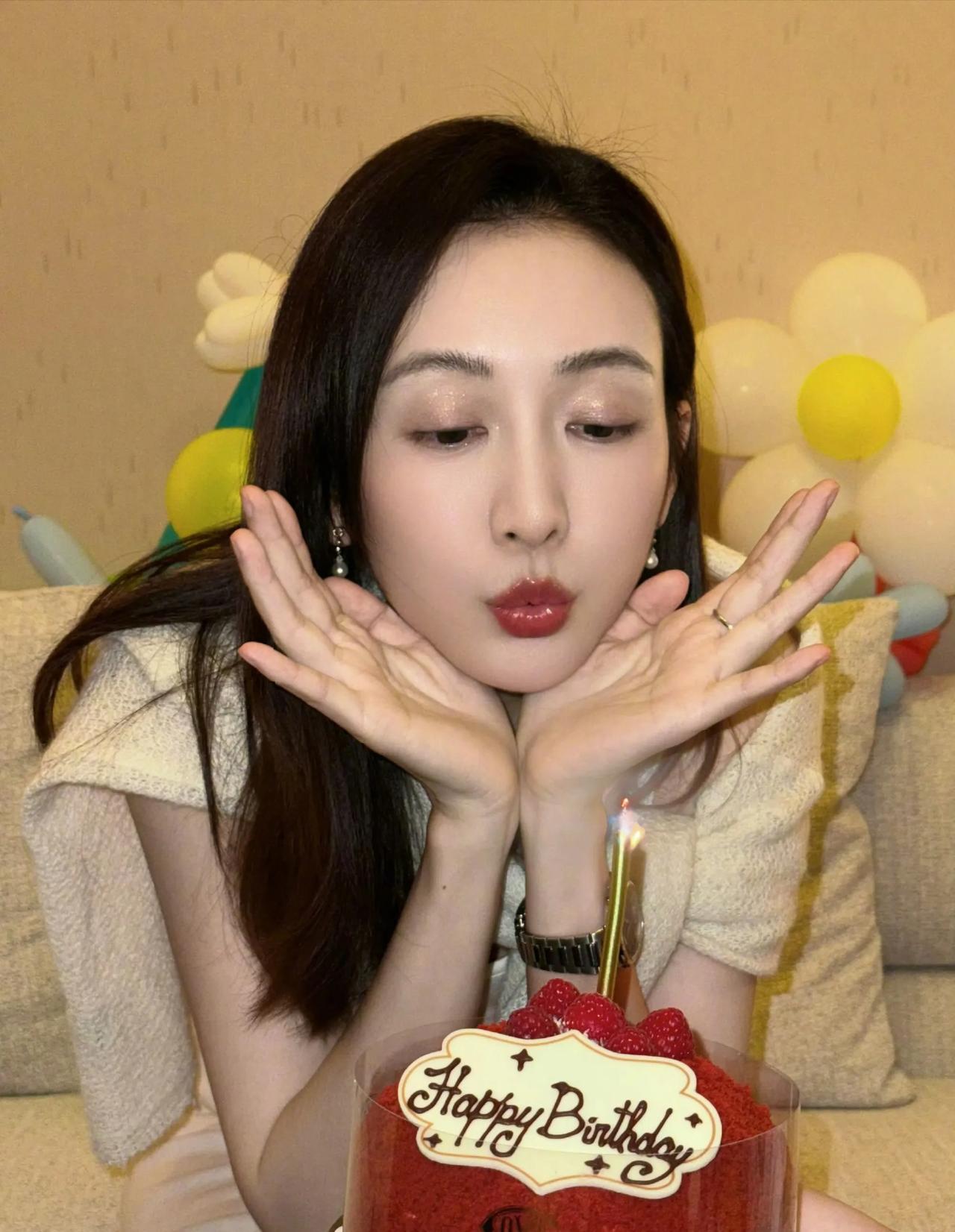 手捧着脸庞，吹着生日蜡烛的王欧满脸洋溢着幸福的表情！精致的妆容，柔美的长发。颜值