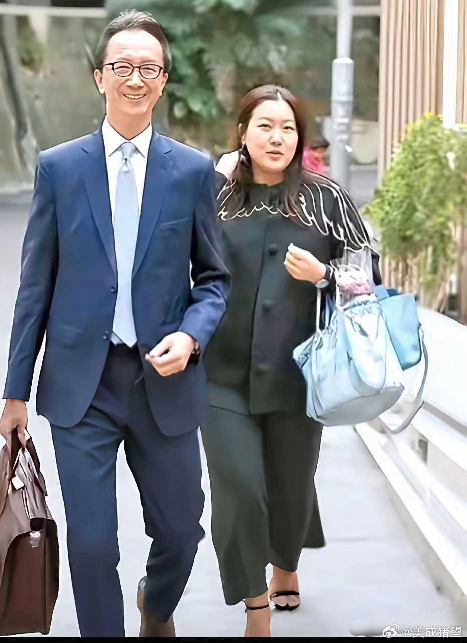 伏明霞挽着老公梁锦松购物归来时的一幕，大包、小包满载而归。 
