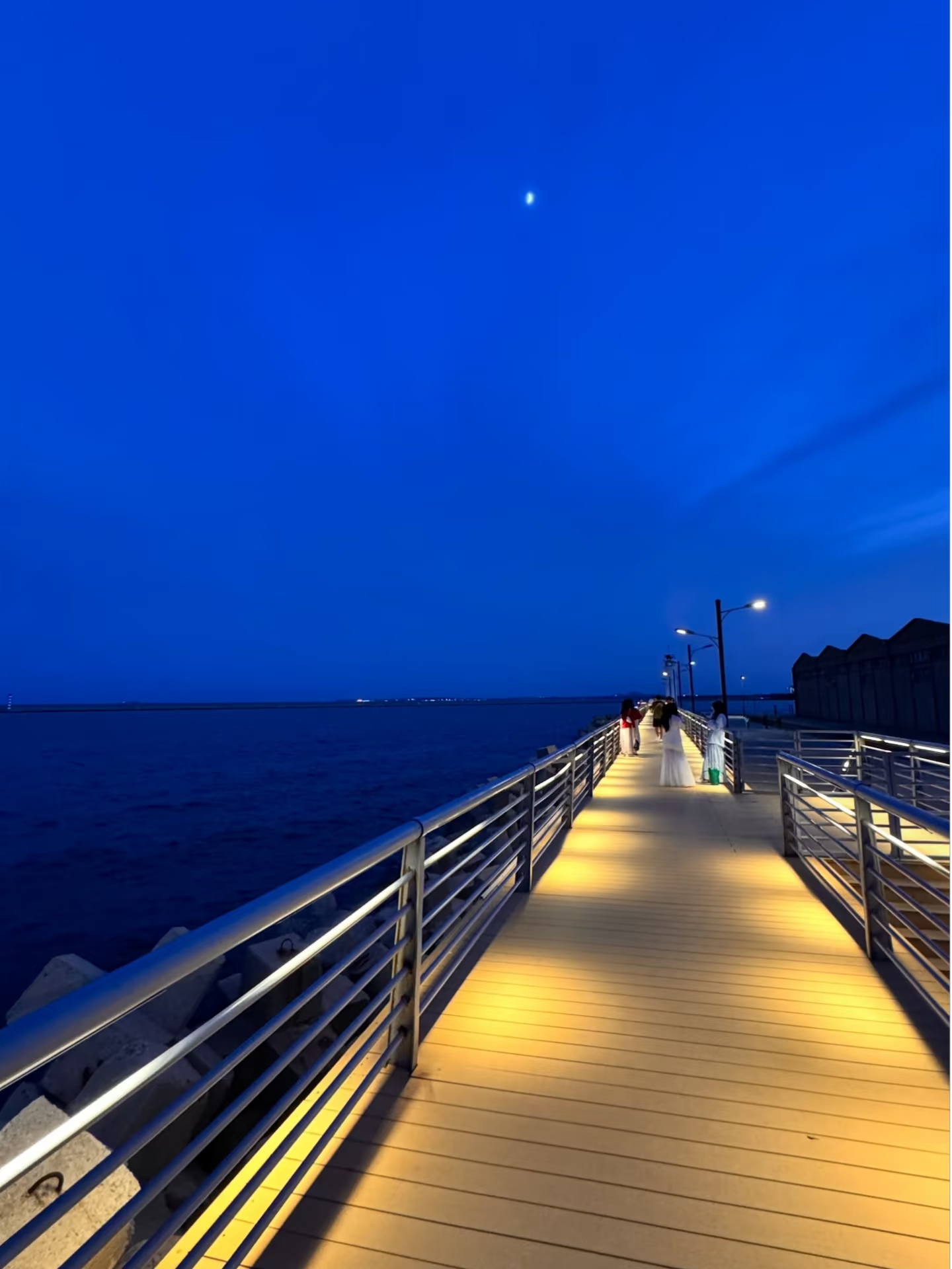 总喜欢在黄昏来海边的街巷闲逛。一头是热热闹闹的市井，摊贩吆喝，灯火次第亮起；另一