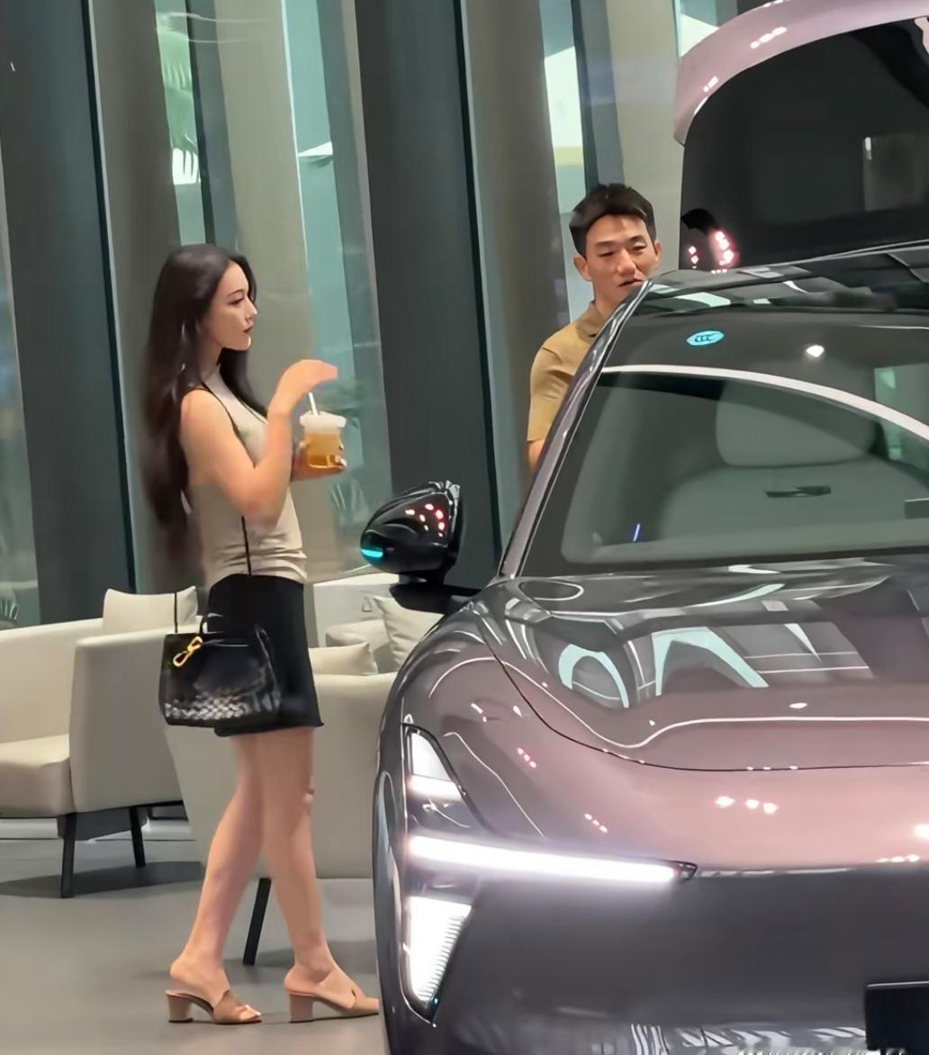39岁的张馨予和老公何捷现身广州一间车企看豪车，她背着4万元的名牌包 打扮时尚贵