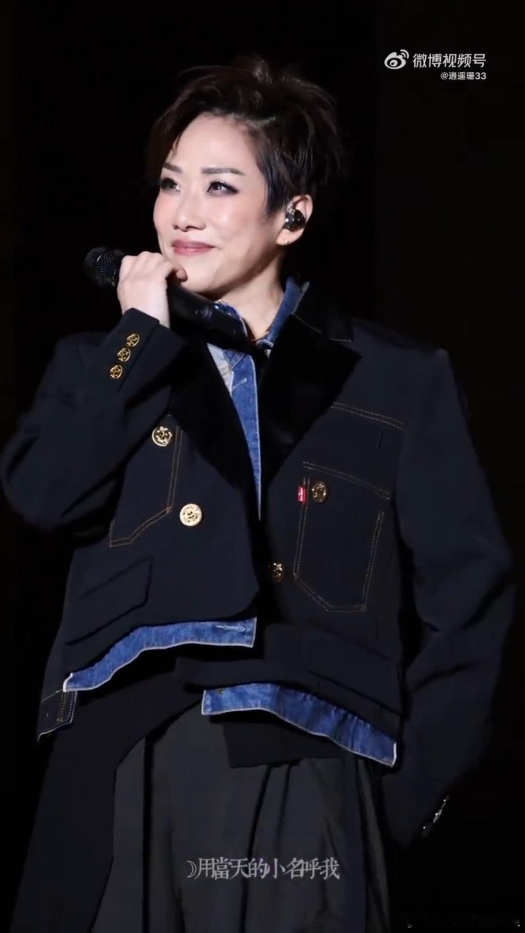 林忆莲舞台上的可爱动作 她站在灯光下唱歌的时候，整个人散发着光芒，可一转身就露出