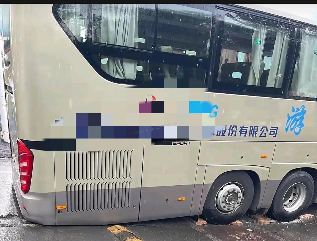 这确实是辆好车，还是能四处奔波的三轴旅行社大巴车。
怪哉！如此平坦的路面，大巴车