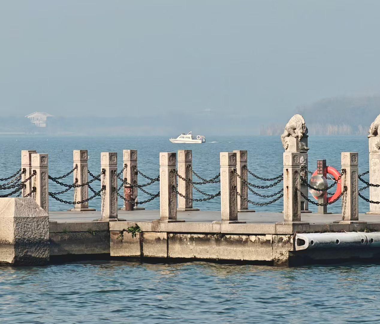 ⛵️薄雾给江面蒙层软纱，码头的石兽守着水的呼吸，那艘船载着蓝，正往光阴的深处游去