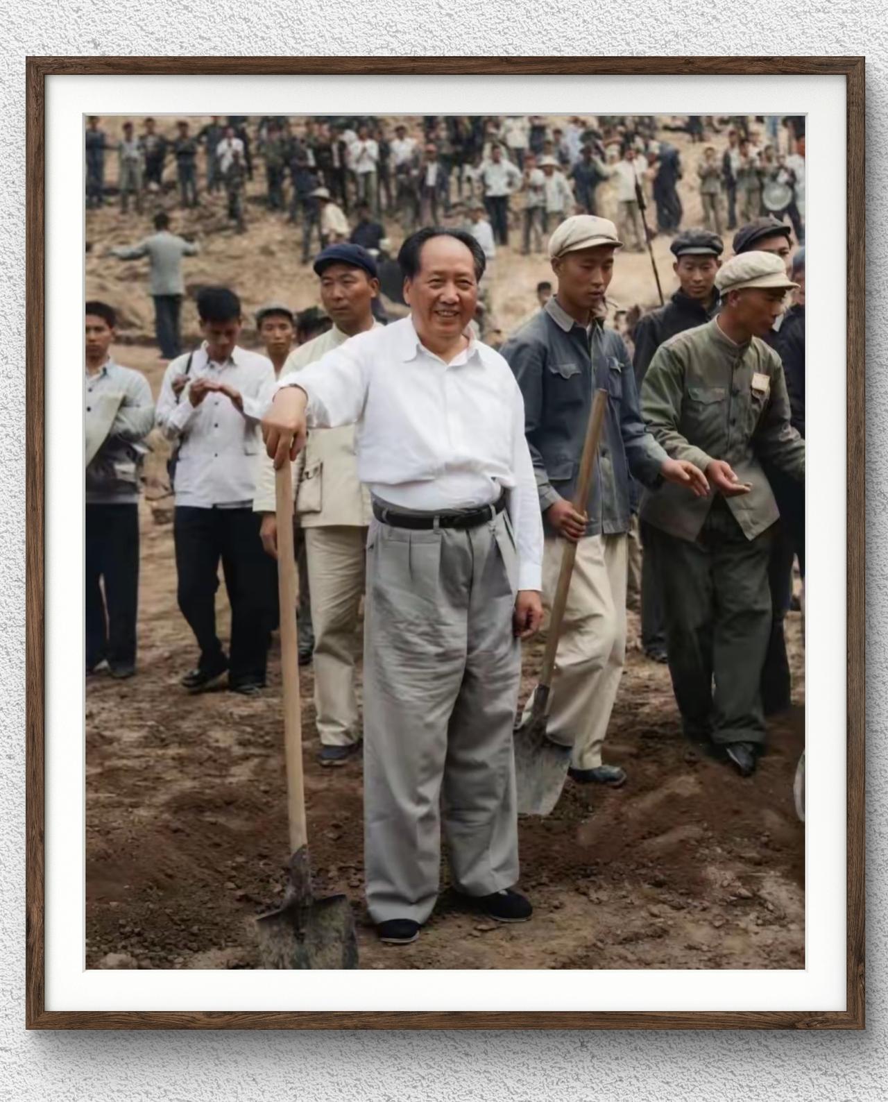 1958年毛主席在十三陵水库参加义务劳动‌，毛主席手持铁锹站在工地，身后是参与劳