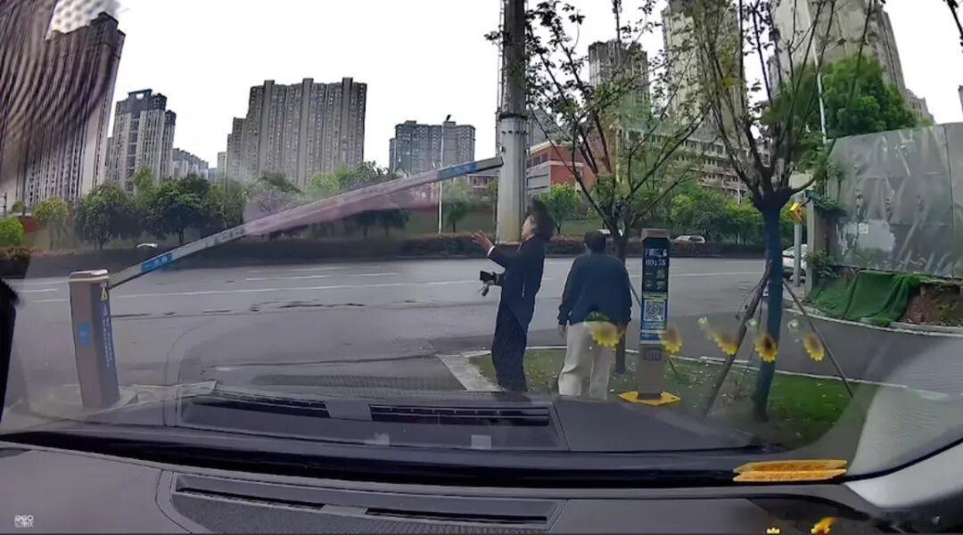 4月16日早上，长沙一小区外停车场出口，两名女子从道闸下钻，恰好有车出来，升起的